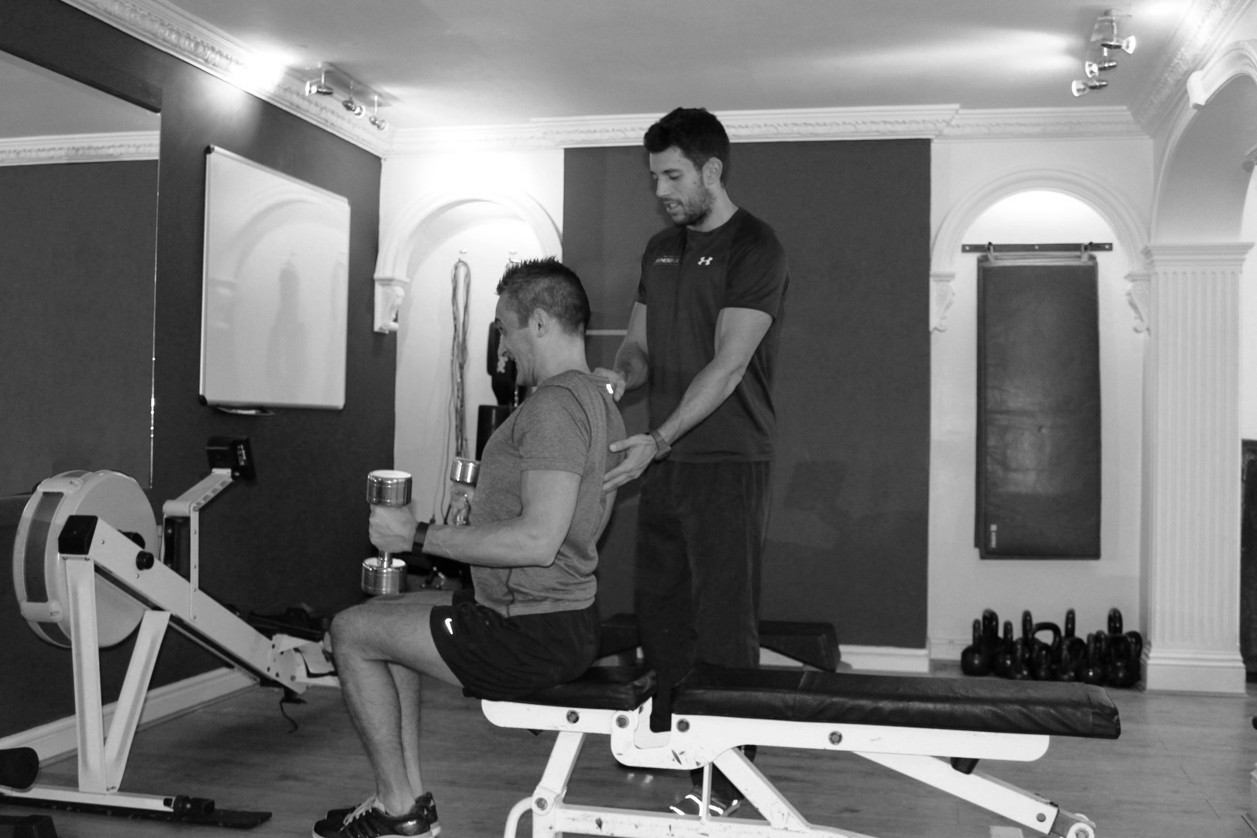 picture of personal trainer with client with dumbells